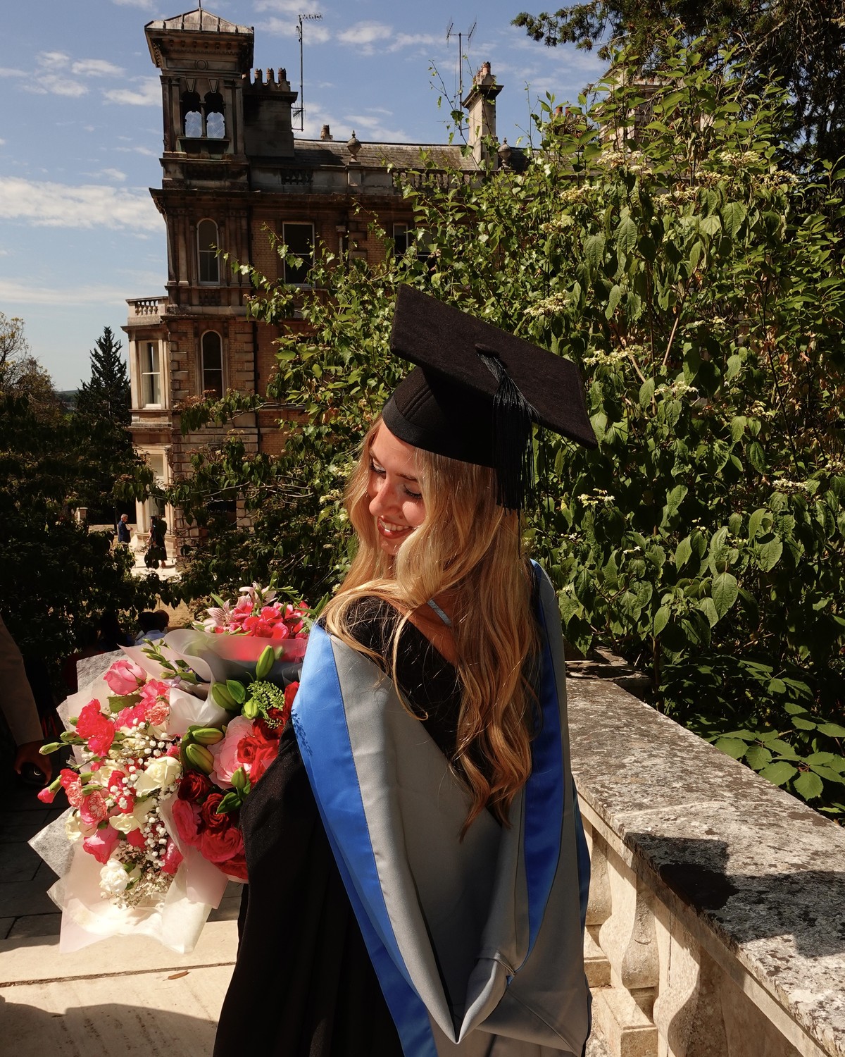 Kornelia celebrating her University of Exeter graduation with a bouquet
